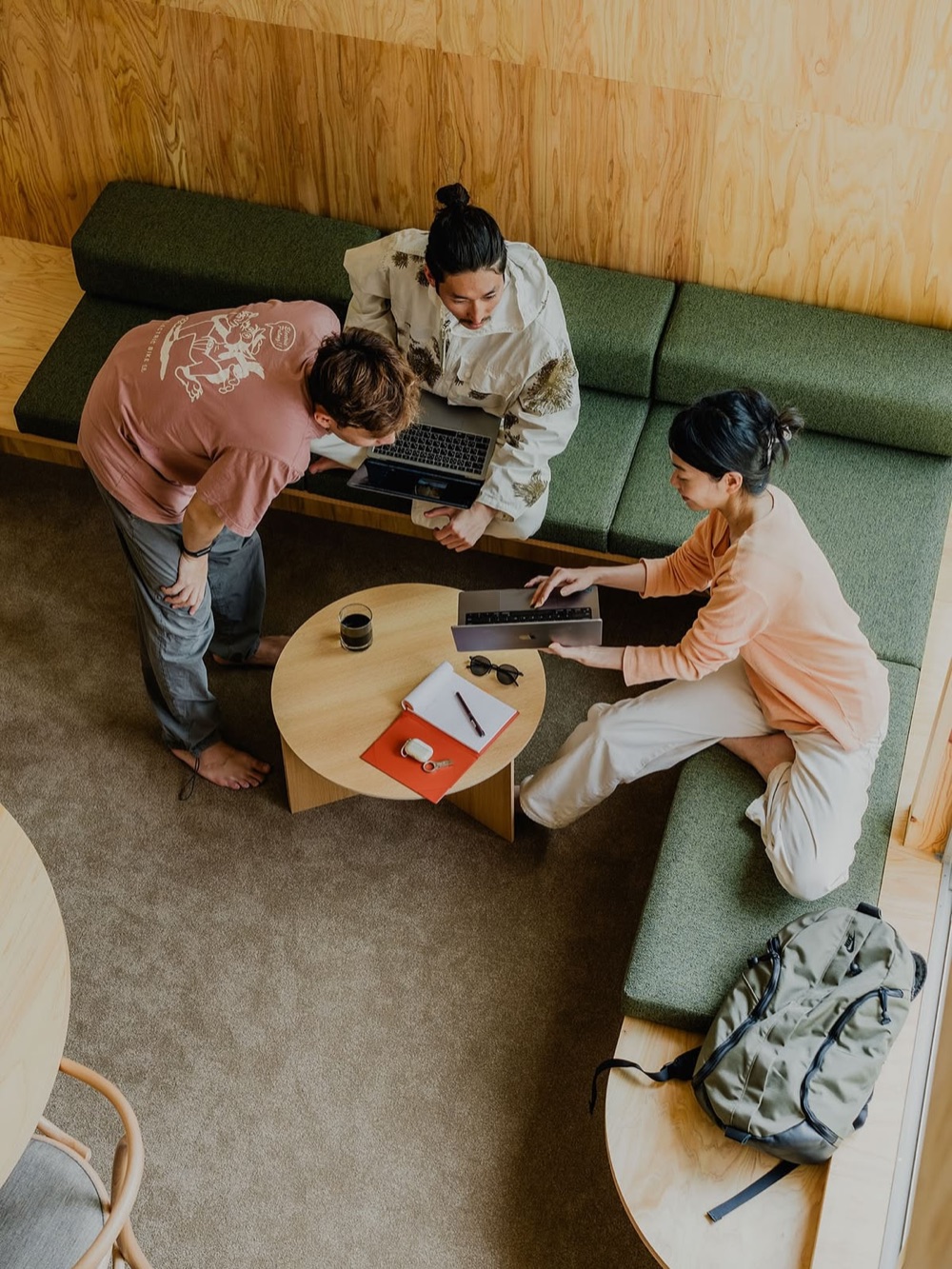 Three people working together around a low table