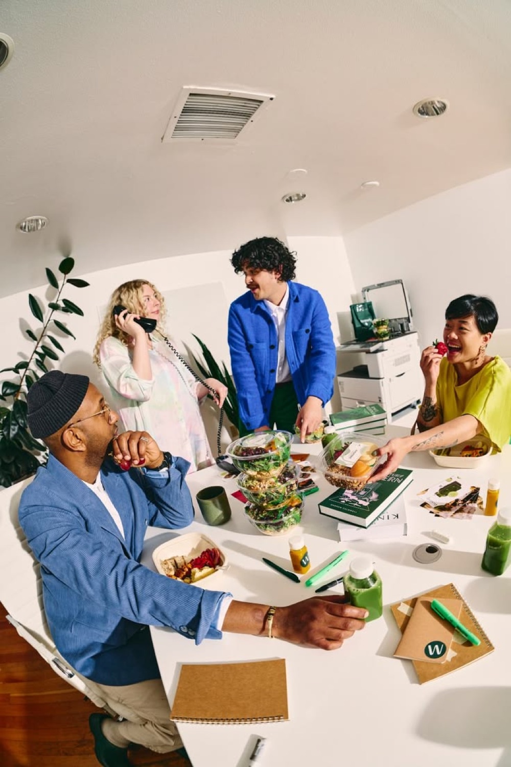 Four people sharing lunch around a work table